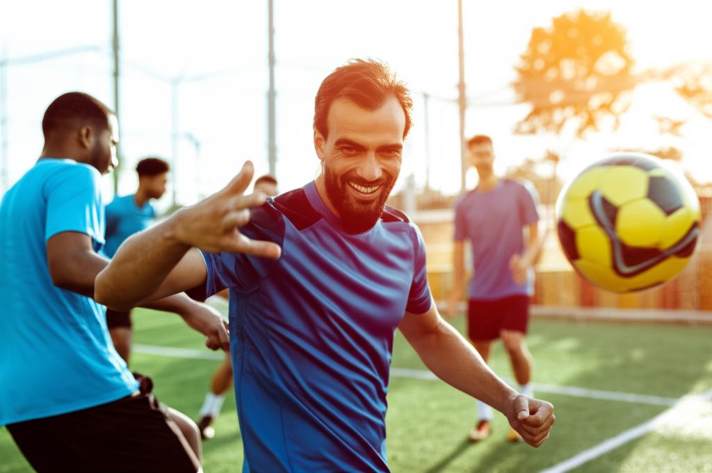 AI prompt: A man smiling and energetic, playing futsal outdoors with friends, looking healthy and active, sun shining.